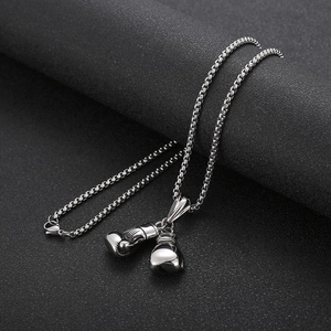 Macro shot of silver titanium steel boxing glove pendant on dark textured background