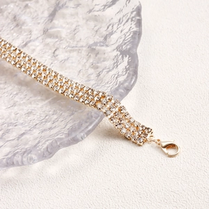 Detailed close-up of a multi-row sparkling rhinestone choker with a gold lobster clasp