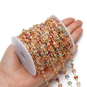 Colorful enamel butterfly chain on a white spool for DIY jewelry making and crafts