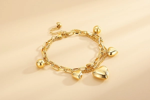 Détail du bracelet double couche doré avec pendentif cœur et chaînes à billes