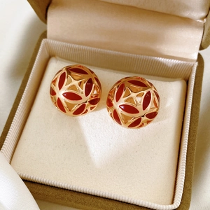 Détail macro de boucles d'oreilles sphère vintage avec émail rouge sur velours