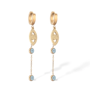 Detail of long gold earrings featuring evil eye charms and light blue enamel drops