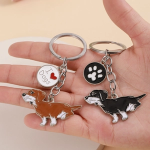 Detail of dachshund keychains set with heart and paw print charms in brown and black