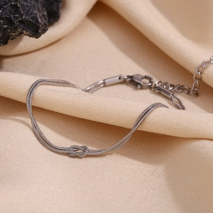 Detail of silver double-layer snake chain bracelet with a knot design and lobster clasp