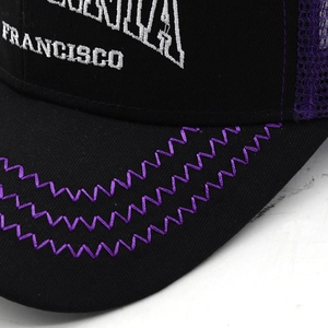 Detail of San Francisco embroidery and zigzag stitching on purple mesh trucker hat