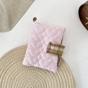Détail du protège-carnet en tissu matelassé rose à motifs cœurs et fermoir écossais