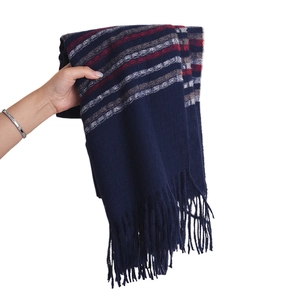 Soft dark blue plaid cashmere scarf with fringes being held against a white background