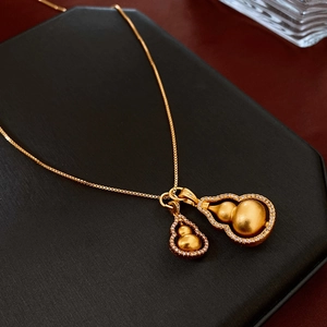 Macro shot of gold-plated double gourd pendant necklace with pavé-set cubic zirconia accents