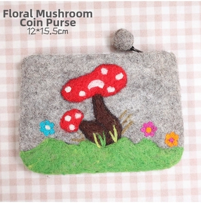Detail view of a handmade grey wool felt wallet with mushroom and flower embroidery