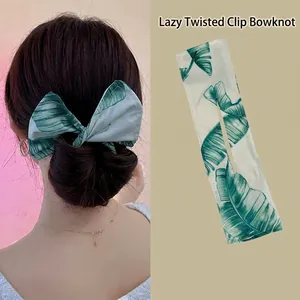 Macro detail of tropical leaf print on fabric twist hair bun maker and style view