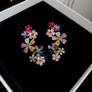 18k gold plated flower stud earrings with vibrant multicolored crystals on black velvet