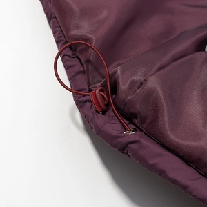 Dettaglio macro della giacca bordeaux con coulisse elastica e fermo in plastica nero