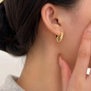 Detail view of 925 silver golden teardrop earrings with a polished mirror finish on model