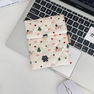 Details der cremefarbenen Stepptasche mit festlichen Welpenprints und Knopfverschluss