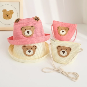 Detail of children's woven straw hat and matching bag set with cute 3D bear embroidery