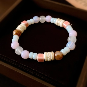 Detail eines bunten Keramik-Perlenarmbands in Pastelltönen in einer Samt-Schmuckschatulle