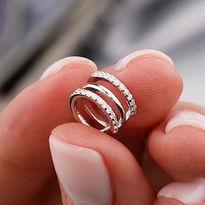 Detailed close-up of a triple-layered silver ear cuff with shimmering micro-pave zircons
