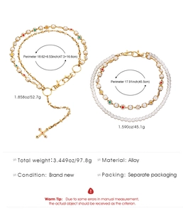 Dettaglio della catena dorata con perle finte, strass colorati e un ciondolo a croce