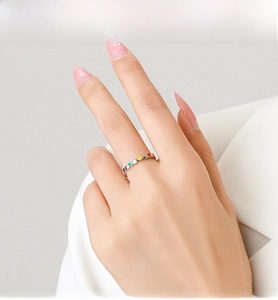 Close-up of a silver S925 ring featuring colorful rainbow enamel heart charms on a hand
