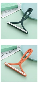 Manual lint remover with ergonomic handle in green and orange color options
