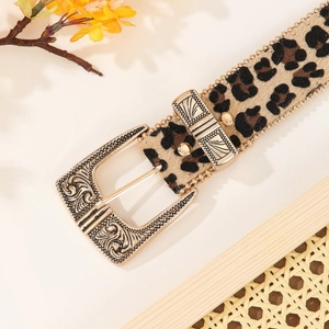 Leopard print belt with vintage gold buckle and beaded edges on a beige background