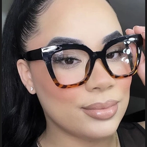 Close-up of dual-tone black and tortoise cat-eye eyeglass frame on a model's face