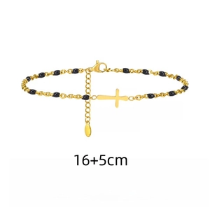 Close-up of golden stainless steel bracelet with black beads and a cross pendant