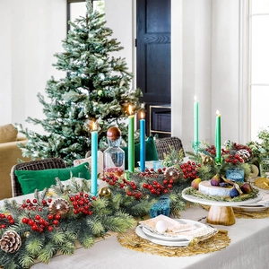 Close-up of 180cm flocked Christmas garland with pine cones and red berries on a festive table