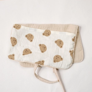 Detail of baby cotton organizer bag featuring brown bear pattern and beige ties