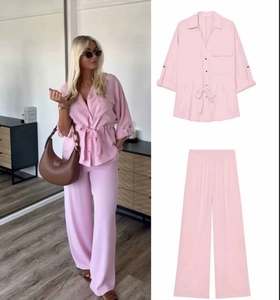 Detail showing pink casual two-piece set with a belted shirt and wide-leg trousers