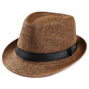 Detail of brown straw fedora hat featuring fine woven texture and black ribbon band