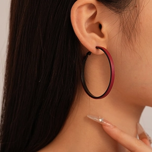 Close-up of model wearing retro geometric hoop earrings with dark red leather finish