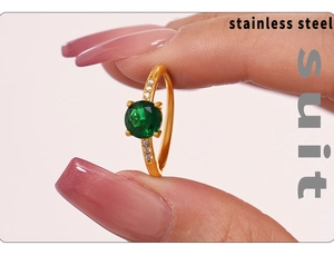 Close-up of gold stainless steel ring with a large green zircon and side diamonds
