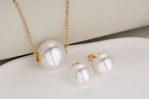 Detailed close-up of a French retro gold necklace with large white pearls and matching studs