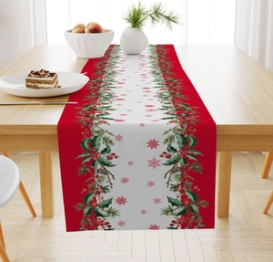 Detail of Christmas table runner with red berries and holly patterns on wooden table