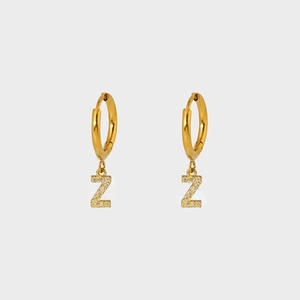 Detail of gold plated stainless steel earring with Z-letter pendant and white zircon stones