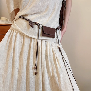 Detail of bohemian waist chain with mini pouch, wooden beads, and printed fabric scarf
