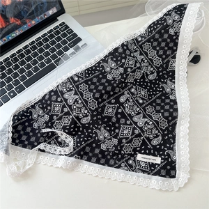 Detail of black paisley triangle scarf with white lace edges and 100% cotton label