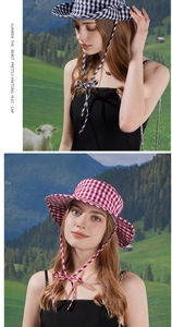 Detail view of plaid sun hats in black and red patterns with decorative chin straps