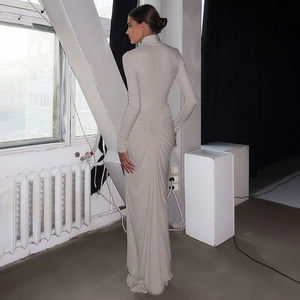 Detail view of the elegant ruched draping on a white slim-fit maxi dress back side
