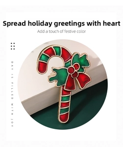 Detail of Christmas candy cane brooch with red bow and green enamel holiday accents