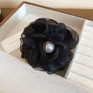 Gros plan détaillé de la fleur en dentelle noire faite main avec une perle centrale