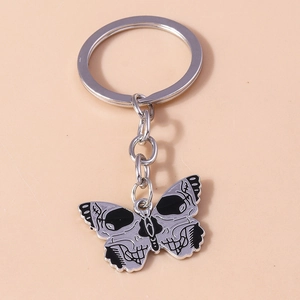 Macro detail of gothic silver metal butterfly keychain with skull pattern design