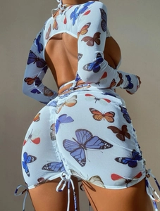 Detail of Y2K butterfly print mesh skirt with side drawstring and backless crop top