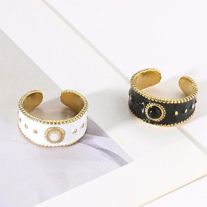 Macro detail of wide enamel drip rings with golden beaded edges and centered natural stones