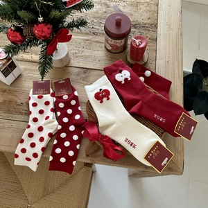 Detailed view of thick Christmas socks with red polka dots and apple embroidery