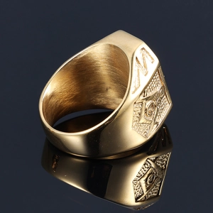 Golden stainless steel Freemason ring with engraved compass and square on black background