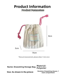 Detail view of cream quilted drawstring pouch showing 14x8x3cm dimensions and pink cord