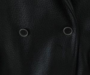 Close-up of black litchi grain faux leather jacket with matte four-hole buttons detail