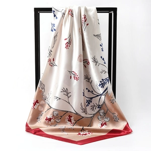 Detail of elegant satin square scarf featuring beige and red shell floral patterns